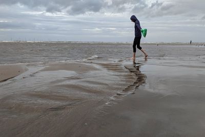 Side view of girl walking on beach