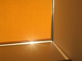 Low angle view of glass window against orange wall