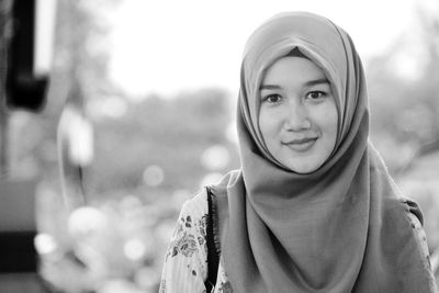 Portrait of smiling young woman against blurred background