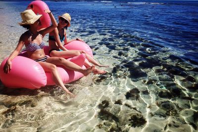 Young women sitting on inflatable raft in sea