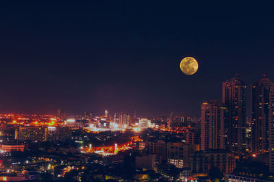 Illuminated cityscape against sky at night