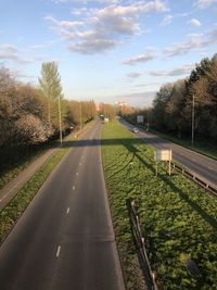 Road amidst field against sky