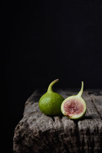 Close-up of fruits on table against black background