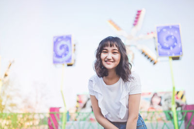 Beautiful asian girl in an amusement park, smiling. summer holidays