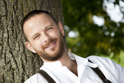 Portrait of smiling man in tree trunk