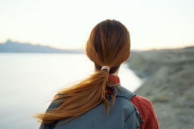 Rear view of woman looking at sea against sky