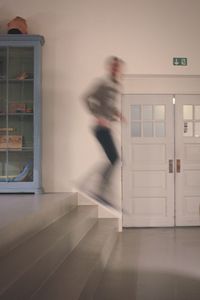 Blurred motion of man walking in corridor