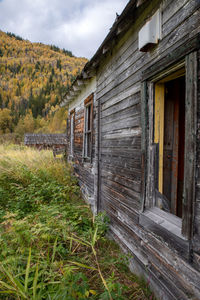 Old house amidst buildings on field against sky