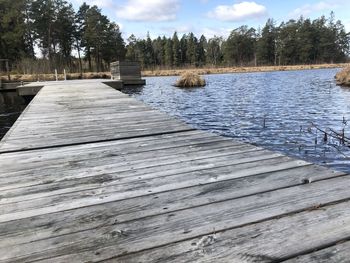 Surface level of pier over lake against sky