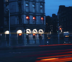 Light trails on city street against buildings at night