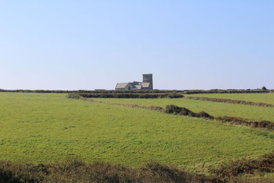 Built structure on grassy field against clear sky