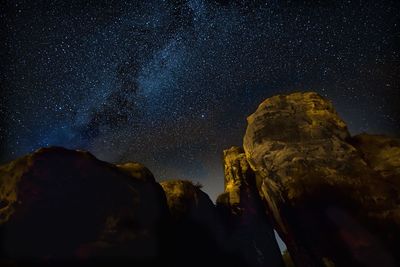 Low angle view of rock formation against sky at night