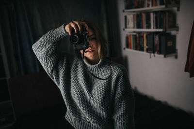 Full length portrait of man photographing at home