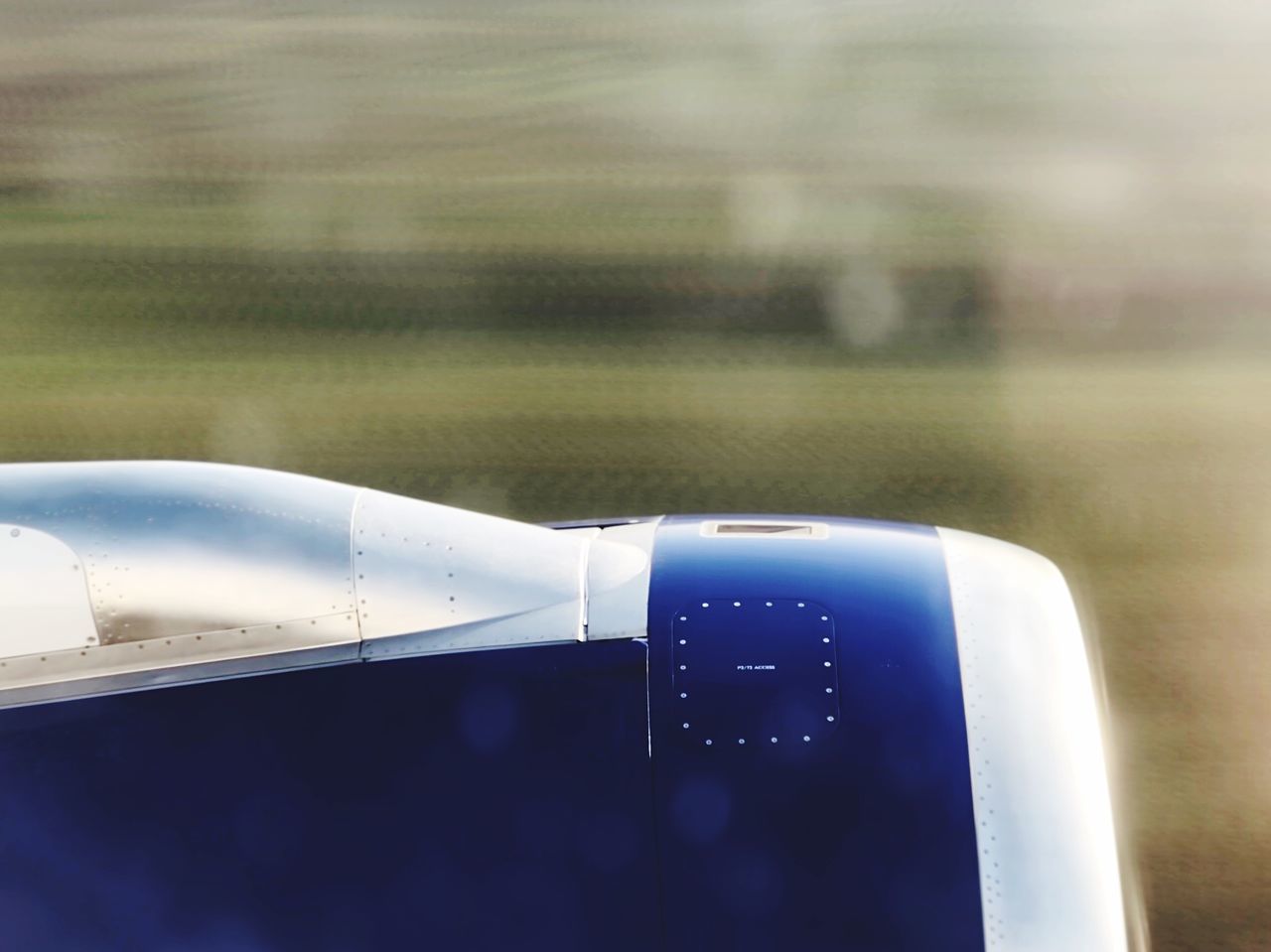 CLOSE-UP OF AIRPLANE ON AIRPORT RUNWAY IN FIELD