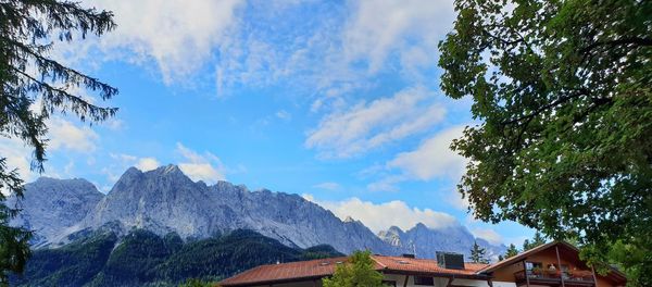 Low angle view of buildings and mountains against sky