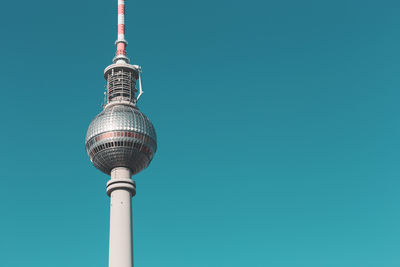 Low angle view of fernsehturm against clear turquoise sky