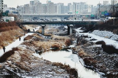 Bridge over river in city during winter