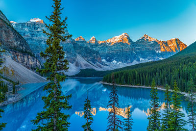 Scenic view of lake and mountains against blue sky