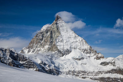 Low angle view of snowcapped mountains against sky