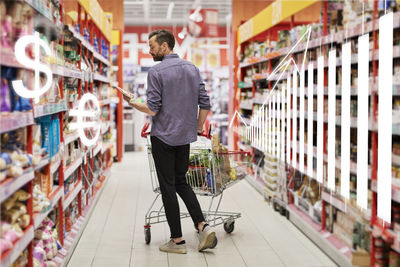 Financial chart and man shopping in supermarket