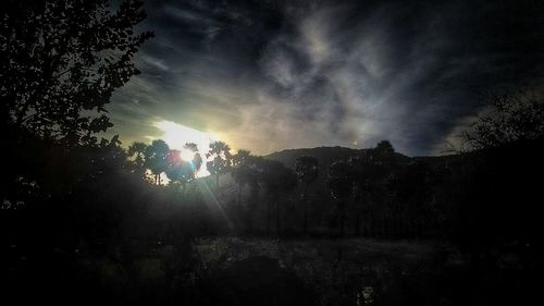 Silhouette landscape against sky at night