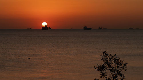 Scenic view of sea against orange sky