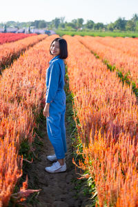 Side view of a young woman standing in field