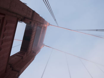 Low angle view of suspension bridge against clear blue sky