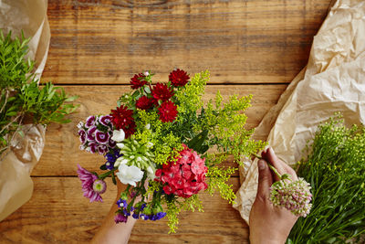 Low section of woman holding flower bouquet