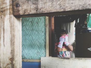 Girl standing against window