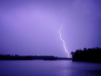 Lightning over lake against sky at night