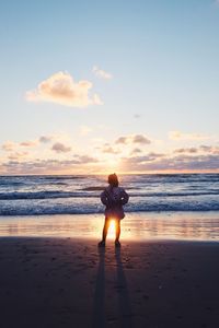 Rear view of silhouette woman standing on beach