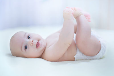 Portrait of baby lying on bed