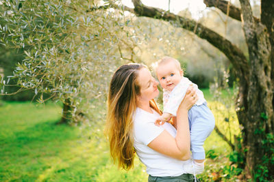 Cheerful mother with son standing at park