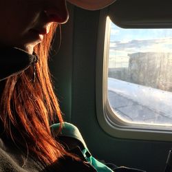 Portrait of woman looking through window