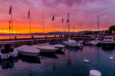 Boats in sea at sunset