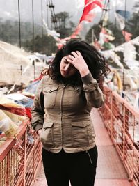 Young woman standing on footbridge on mountain