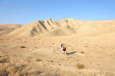 Full length of man on arid landscape against sky