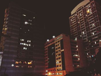 Low angle view of city lit up at night