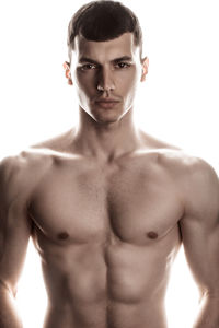 Shirtless muscular man standing against white background