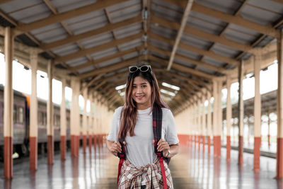Portrait of a young woman traveler with small backpack on the railway station. asian woman