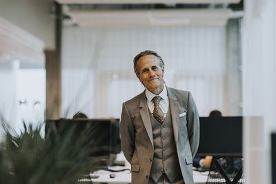Portrait of smiling mature businessman standing in office