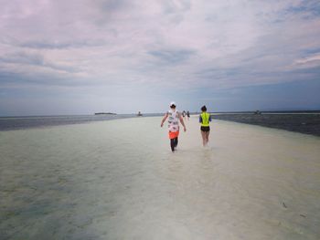 Rear view of boys walking on beach