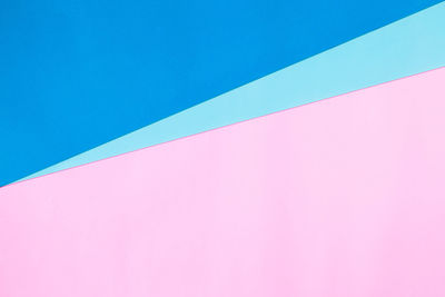 Low angle view of pink wall against blue sky