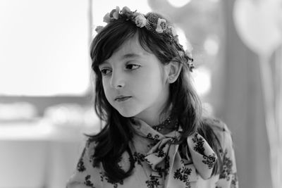 Close-up of girl wearing flowers while looking away