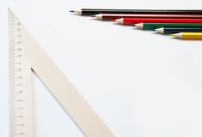 High angle view of pencils on table against white background