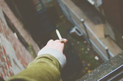 Close-up of hand holding cigarette