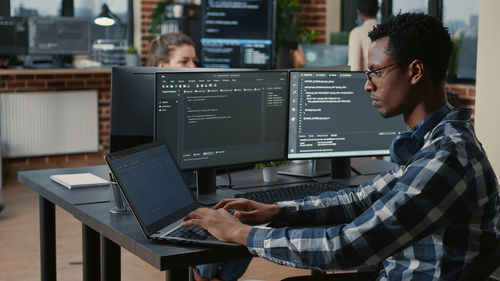 Side view of man using laptop on table