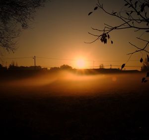 Scenic view of silhouette field against sky at sunset