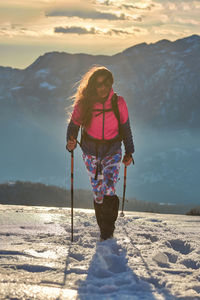 Girl walks in the snow during an alpine trek